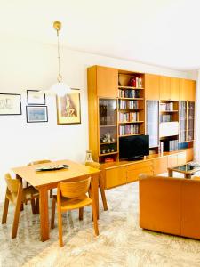 un soggiorno con tavolo in legno e TV di Via Solaro, appartamento in pieno centro a Formia
