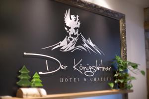 a sign for a hotel and climbers on a shelf at Berghotel Der Königsleitner - Adults only in Königsleiten