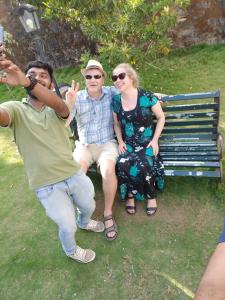 un gruppo di persone seduti su una panchina del parco di Three Roots Resort a Sultan Bathery