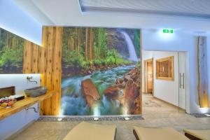 a room with a waterfall mural on the wall at Berghotel Der Königsleitner - Adults only in Königsleiten