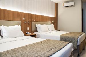 リオデジャネイロにあるホテル アストリア コパカバーナのベッド2台、電話が備わるホテルルームです。