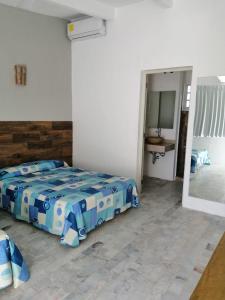 a bedroom with a bed in a room with a mirror at Hotel Villa Mexicana Puerto Escondido in Puerto Escondido