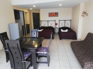 a living room with a table and chairs and a bedroom at Hotel Las Torres Gemelas Acapulco in Acapulco