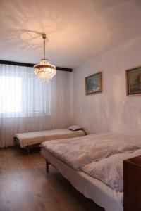 a bedroom with two beds and a chandelier at Chalupa GABIKA in Plavecké Podhradie