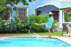 a woman is jumping into a swimming pool at Bungalows Santa Cruz in Puerto Escondido