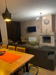 een woonkamer met een bank en een open haard bij Bakuriani Cozy Villa #4 in Bakuriani