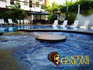 uma piscina num hotel com um sinal na água em Hotel Cacique Guaicani em Melgar