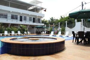 een resort met een zwembad en tafels en stoelen bij Hotel Cacique Guaicani in Melgar