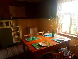 una mesa de madera con platos y gafas en la cocina en Paali cottages, en Tornimäe