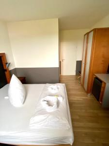 a bedroom with a bed with two towels on it at Hotel Castellana in Lessien