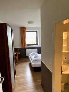 Habitación pequeña con cama y ventana en Hotel Castellana, en Lessien