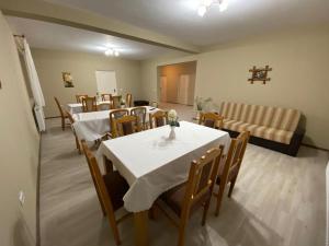 a dining room with tables and chairs and a couch at Casa Andrei Retezat in Haţeg