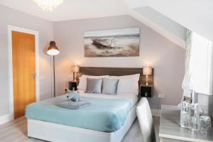 sypialnia z łóżkiem z niebieską pościelą i obrazem w obiekcie Caravogue House w mieście Trim