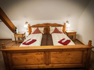 a large wooden bed with two red pillows on it at Hotel Landgasthof Sonne in Mahlberg