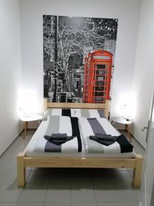 Bett in einem Zimmer mit einer roten Telefonzelle in der Unterkunft Apartmani Sirmium in Sremska Mitrovica