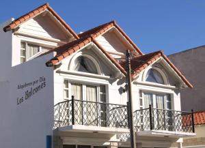 een wit huis met een balkon en een bord bij Los Balcones Madryn in Puerto Madryn