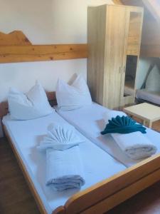 una camera con 2 letti con lenzuola e cuscini bianchi di OMLADINSKI HOTEL ROSTOVO a Bugojno