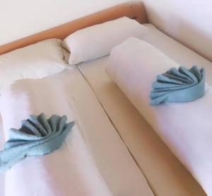two pillows on a bed with blue mitts on it at OMLADINSKI HOTEL ROSTOVO in Bugojno