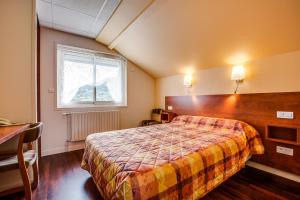 Rúm í herbergi á Logis Hôtel Belle Vue