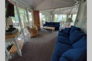 een woonkamer met een blauwe bank en een tafel bij Unit 11-Treetop 2 Bedroom Villa in Four Seasons