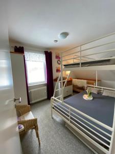 a bedroom with two bunk beds and a chair at Pension Haus am Wald in Braunlage