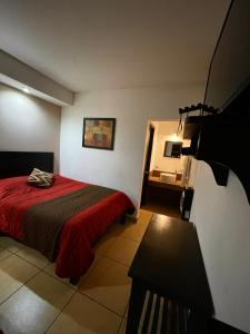 a bedroom with a bed with a red blanket at Hotel Los Valles in Creel