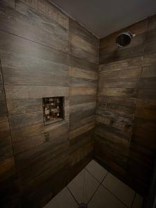a shower with wooden walls and a small window at Hotel Los Valles in Creel
