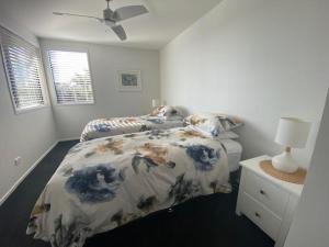 a bedroom with a bed with a floral comforter at Dune View Accommodation in Mangawhai