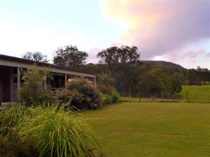 a house with a large yard in front of a field at Rural Ambience with Netflix in Mount George