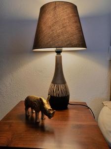 eine Lampe auf dem Tisch mit einem Spielzeugschwein drauf in der Unterkunft L'Evidence in Prades