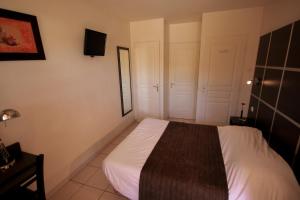 a small bedroom with a bed and a tv at Résidence Côté Sud La Bouilladisse in La Bouilladisse