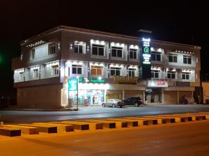 un bâtiment avec une voiture garée devant lui dans l'établissement الزمردة للشقق المخدومة, à Ash Shuqayq