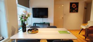 a living room with a table and a vase of flowers at Appartementen Dorp & Duin in Egmond aan Zee