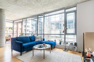 a living room with a blue couch and a table at Spacious and Quiet Corner Apartment Downtown Toronto in Toronto