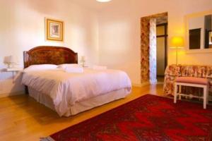 a bedroom with a large bed and a red rug at VILLA CON VISTAS MAR/PISCINA PRIVADA/BBQ in Málaga