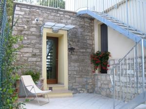 ein Steinhaus mit einem Stuhl auf einer Terrasse in der Unterkunft Casa Titty in Serre di Rapolano