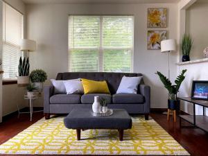 a living room with a blue couch and a yellow rug at OU-Walk to Campus , Downtown ; Designer Studio in Oklahoma City