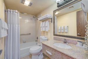 Sierra Suites Boutique Hotel في سييرا فيستا: حمام مع حوض ومرحاض وحوض استحمام