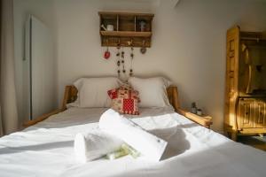 łóżko z białą pościelą i poduszkami w obiekcie Le Petit Chalet - Cosy studio in Lathuile for 2 people w mieście Lathuile