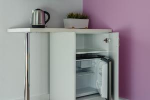 a white refrigerator with its door open next to a purple wall at Enklawa u Zosi in Szczawnica