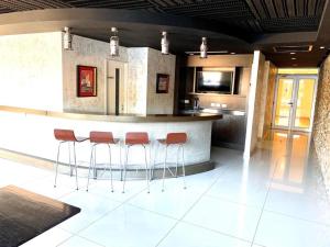 a kitchen with a bar with red stools at Departamentos Farley in Tigre