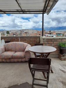 eine Couch und ein Tisch und Stühle auf einer Terrasse in der Unterkunft Hostal Don Cristobal in Ayacucho