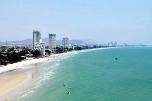 a view of a beach with people in the water at Sunshine Hostel in Hua Hin