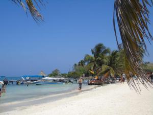 a group of people on a beach with boats at AquaMarina Hostal in Tolú