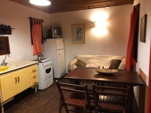 a kitchen and dining room with a table and a kitchen and a couch at Cabañas Puerto Diablo in Punta Del Diablo