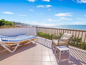 einen Balkon mit einem Tisch, einem Stuhl und Meerblick in der Unterkunft Villa in La Cala de Mijas by the Beach in La Cala de Mijas