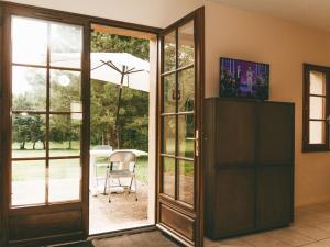 Une porte ouverte s'ouvre sur une terrasse avec une chaise. dans l'établissement Modern holiday home with dishwasher, in natural region, à Moncontour-de-Poitou
