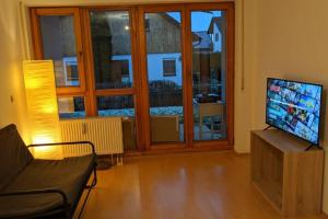 a living room with a television and a large window at Helle Terrassenwohnung am Waldrand in Nürtingen