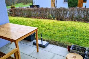a table sitting on a patio next to a yard at Helle Terrassenwohnung am Waldrand in Nürtingen