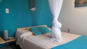 a blue bedroom with a bed with a curtain at Cabañas Puerto Diablo in Punta Del Diablo